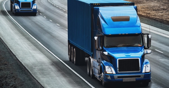 Blue semi-truck on highway.