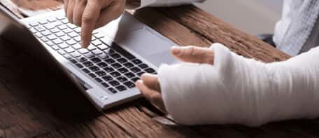 Person with arm cast using laptop