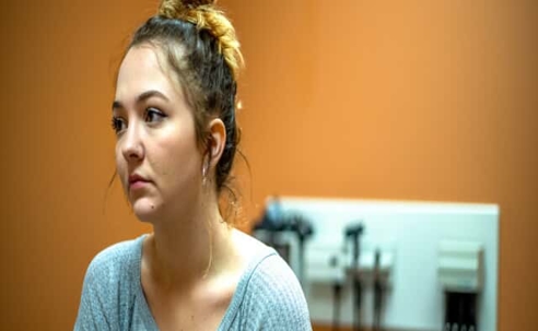 Woman sitting alone in doctor's office with neutral expression
