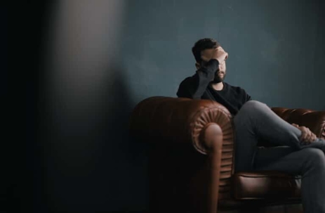 Man sits forlorn on leather chair